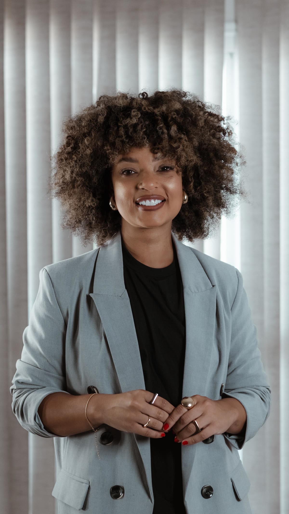 Sarah Fernanda de blazer, sorrindo, em retrato profissional