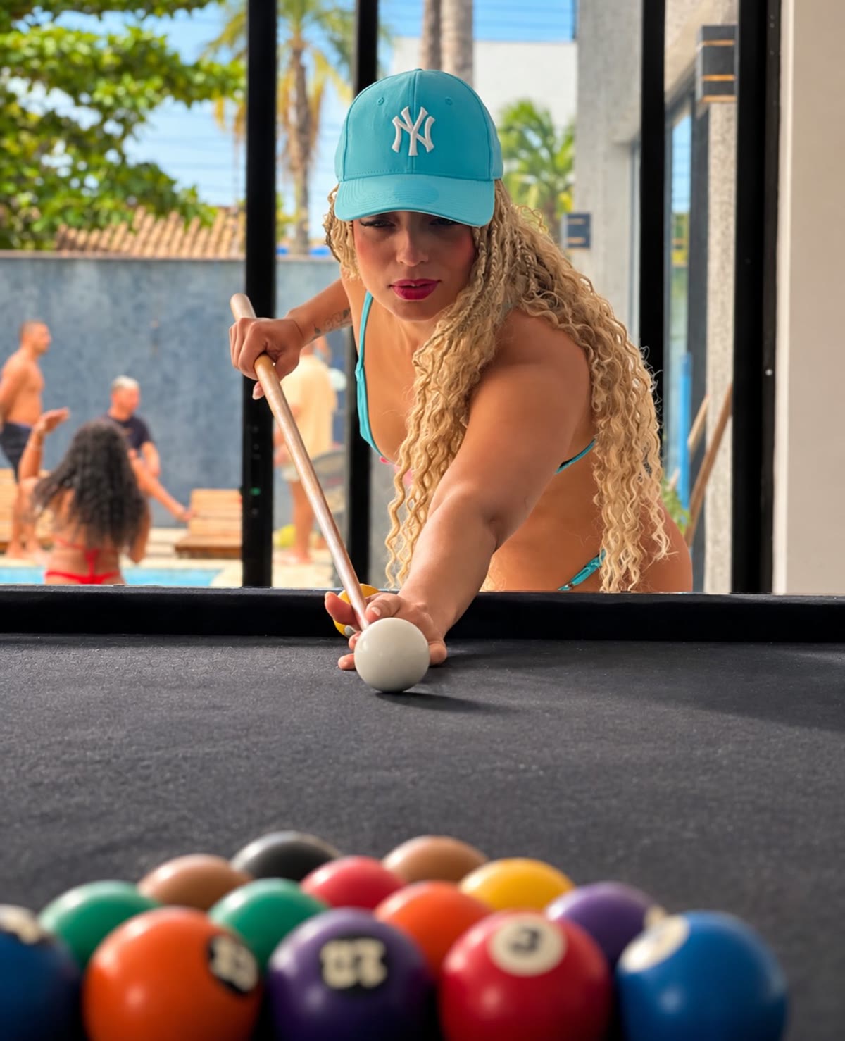 Sarah Fernanda jogando sinuca de boné